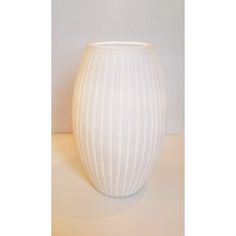 a white vase sitting on top of a table