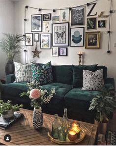 a living room filled with green couches and lots of framed pictures on the wall