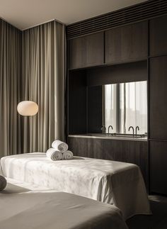 two beds in a hotel room with towels on top of them and a mirror behind them