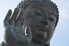 there is a large buddha statue with his hands in front of it's face