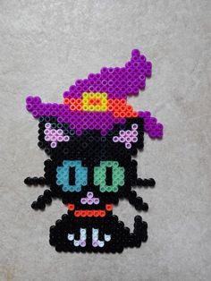 a beaded cat with a purple hat on it's head