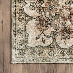 an old rug is laying on the floor with wood in the background and a wooden wall behind it