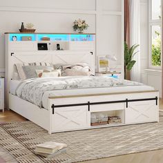 a white bed with drawers underneath it in a room next to a rug and window