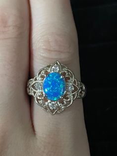 Victorian style filigree oval Blue Opal and White Topaz Accented Ring  Metal: 925 Sterling silver Size: 8.5 Weight: 3.05 g Stones: Blue Opal and 4 White Topaz Blue Oval Opal Ring Fine Jewelry, Heirloom Style Oval Opal Ring, Blue Hallmarked Opal Ring For Wedding, Classic Blue Oval Opal Ring, Oval Blue Opal Ring Hallmarked, Blue Opal Ring For Formal Occasions, Formal Blue Opal Fine Jewelry Ring, Formal Blue Opal Ring Fine Jewelry, Oval Filigree Ring With Center Stone