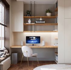 a white chair sitting in front of a desk with a monitor on it's side