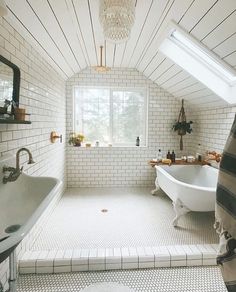 a bathroom with a tub, sink and window