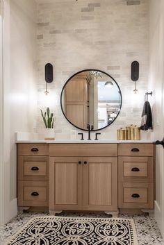 a bathroom with a large round mirror above the sink and wooden cabinetry on the wall