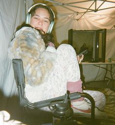 a woman sitting in a chair with headphones on