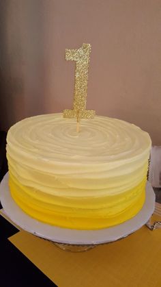 there is a yellow cake with a one on it and the number 1 on top