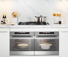 two ovens in a kitchen with marble counter tops