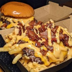 a cheeseburger with bacon and fries in a box