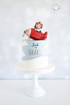 there is a cake that has a doll on it and the words, just one