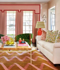 a living room filled with furniture and pink walls