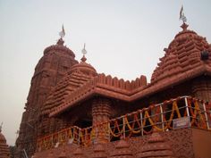 an intricately designed building with orange decorations on the roof and side walls, in india