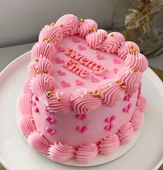 a heart shaped cake with pink frosting and hearts on it that says happy birthday