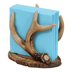 a book with antlers on it is sitting on a tree stump and has been carved into the shape of a deer's head