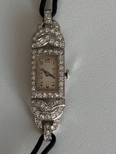 Ladies' wristwatch, cased decorated with 8/8 cut diamonds, silver dial, Arabic numerals, black cord bracelet, mechanical movement with manual winding entirely revised. French hallmark, master's hallmark. Length: 15 cm. Pattern with diamonds: 5 cm. Gross Weight: 17.58 g Additional information: We issue an invoice and a certificate of authenticity issued by our qualified gemologist (LFG Paris). Our photos are not reworked and are taken in an environment of natural light. We can send you a short vi Art Deco Platinum Evening Watches, Platinum Art Deco Evening Watches, Antique Platinum Evening Watches, Platinum Art Deco Watch For Formal Occasions, Art Deco White Gold Diamond Watch, Art Deco Silver Diamond Watch In Platinum, Art Deco Platinum Diamond Watch In Silver, Art Deco Silver Diamond Platinum Watch, Vintage Diamond Watch With Rectangular Dial