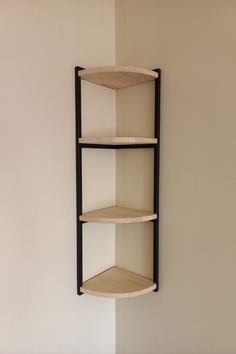 a corner shelf with three shelves mounted on the wall