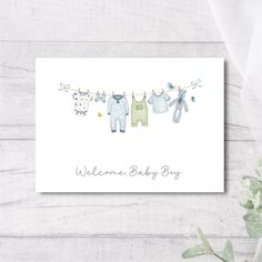 a card with baby clothes hanging on a line