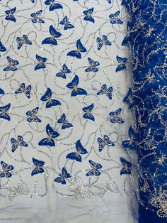 two pieces of blue and white fabric with butterflies on them, one in the middle