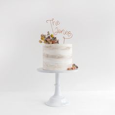 a white cake with the words the jones on top is sitting on a small stand