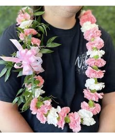 a man wearing a pink and white flower lei with flowers on it's neck