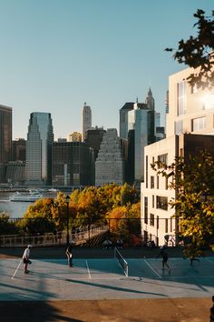 people playing tennis in front of the city skyline