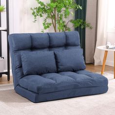 a blue futon sofa bed in a living room