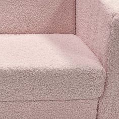 a close up of a pink couch with a cat on it's back legs