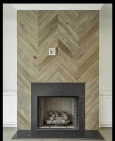 a fireplace with a chevron wood wall behind it