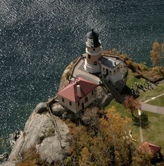 an aerial view of a lighthouse on top of a rock