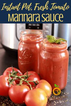 two jars filled with marinara sauce next to tomatoes