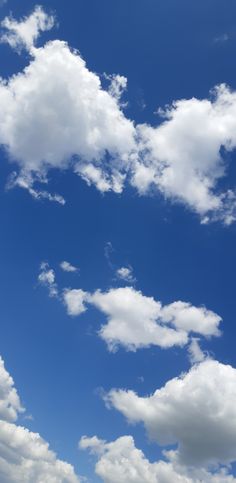 an airplane is flying in the sky with white clouds above it and blue skies below