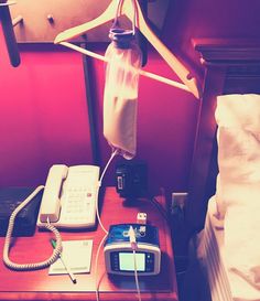 thelifeoflani: “ When you’re away from home and have no IV pole but still need to feed!!  ” [Image description: A hotel nightstand containing a phone, alarm clock, and some medical supplies. A bag... Hotel Nightstand, Phone Alarm, Medical Equipment Storage, Enteral Feeding, Hanging System