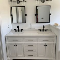 a bathroom with two sinks and mirrors on the wall