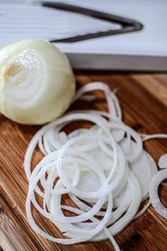 onions are being sliced on a cutting board