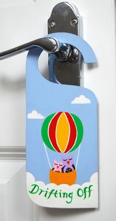 a door hanger with an image of a hot air balloon and cats on it