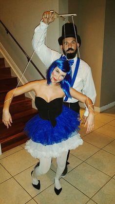 a man and woman dressed in costumes posing for the camera with strings attached to their heads