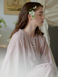 a woman with flowers in her hair sitting down