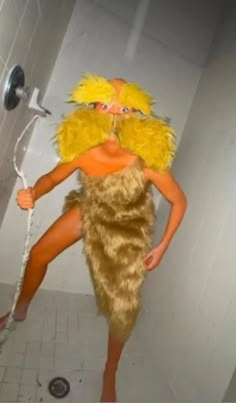 a woman in a costume standing on a shower head and holding a hose to her mouth