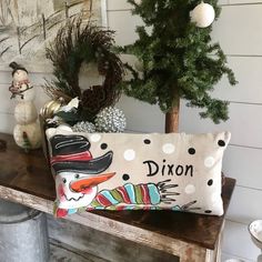 a wooden bench with a christmas tree and other decorations on the table in front of it