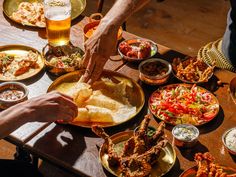 people are sitting at a table full of food