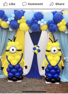 two yellow and blue minion balloons sitting on top of each other in front of an arch