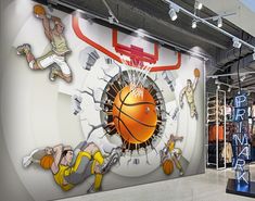 an indoor basketball court with murals on the wall