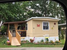 a mobile home with stairs leading up to the front door and steps down to the porch