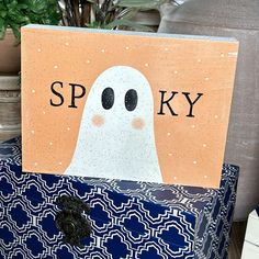 a wooden sign that says spooky with a ghost on it's face