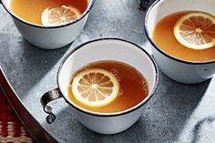 three cups of tea with lemon slices in them