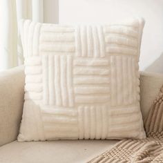 a white pillow sitting on top of a couch