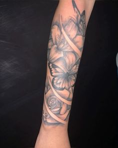 a woman's arm with flowers and butterflies on it