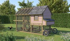 a chicken coop in the middle of a garden with two chickens on it's side